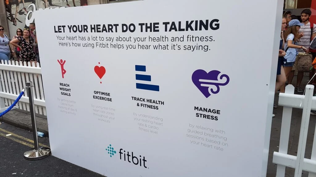 A large Fitbit board on Regent Street: “Let your heart do the talking”, with four short benefits covering weight goals, exercise, health tracking and stress